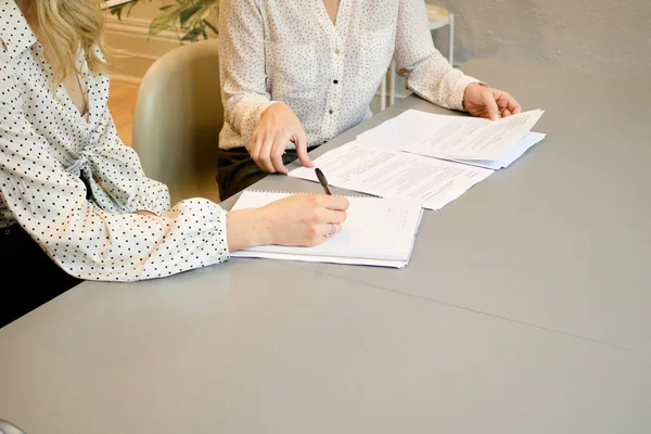 Rekruter siedzi przy biurku z laptopem, na ekranie widać listę CV i ikonę AI analizującą zgłoszenia